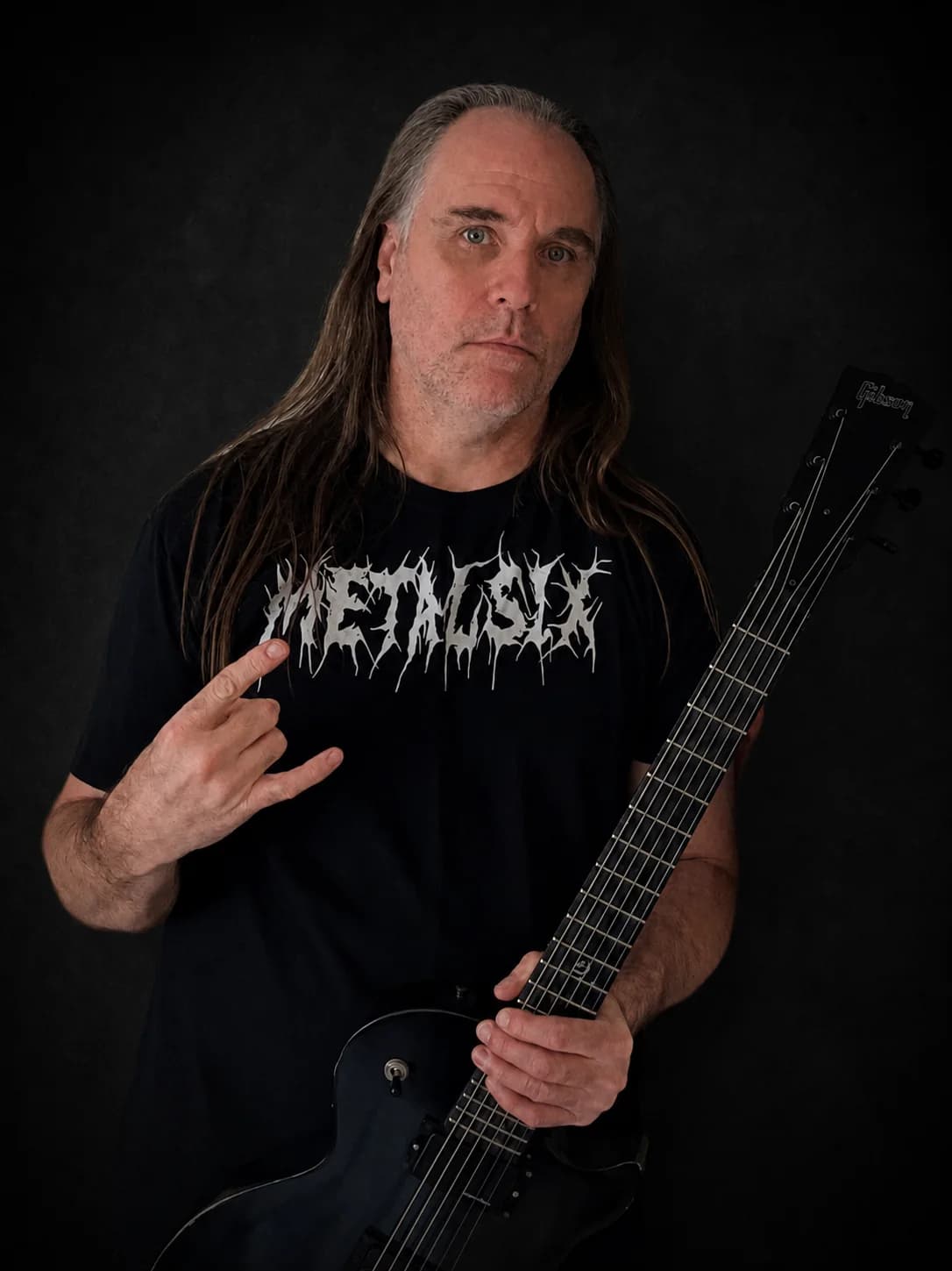Matt holding a black metal guitar